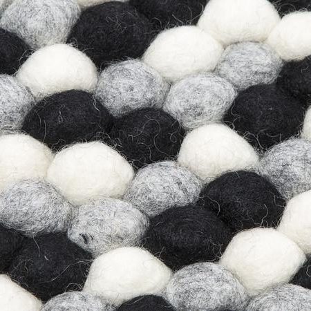 Sort og hvidt håndlavet kugletæppe af 100% ren uld tilføjer hygge og stil. Blødt uld materiale og enestående design. Perfekt til at skabe en varm atmosfære i dit hjem.